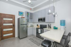 a kitchen with a refrigerator and a table with chairs at Acqua Di Mare #3 condo in Roatan