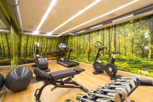 a fitness room with a wall of trees at ABC Swiss Quality Hotel in Chur