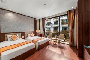 a hotel room with two beds and a balcony at Harmony HaLong Hotel in Ha Long