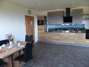 a kitchen with a long table and a large kitchen at Ferienwohnung Steger in Mattsee