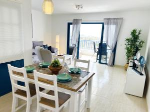 uma sala de jantar e sala de estar com mesa e cadeiras em LOS CHARCOS TERRACE VIEW em Costa Teguise