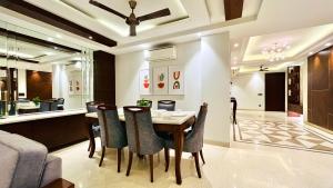 uma sala de jantar e sala de estar com mesa e cadeiras em Olive Service Apartments - DLF Cyber City em Gurgaon