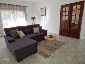 un soggiorno con un divano viola e un tavolo di Casa Almeida - Castelo Branco a Castelo Branco