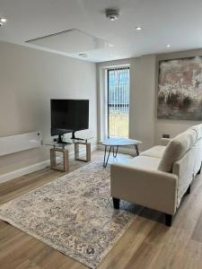 a living room with a couch and a flat screen tv at Central Leeds modern 1bed apartment in Leeds