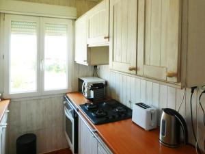 a kitchen with a stove and a microwave at UN CHALET EN BOIS A LA PLAGE in Gruissan