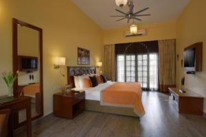 a bedroom with a large bed and a large mirror at Gir Serai - IHCL SeleQtions in Sasan Gir