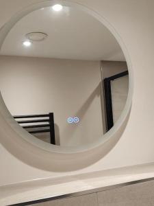 a circular mirror on a wall in a room at Central Leeds modern 1bed apartment in Leeds