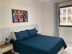 - une chambre dotée d'un lit bleu et d'une peinture murale dans l'établissement Barrabela 130, à Rio de Janeiro