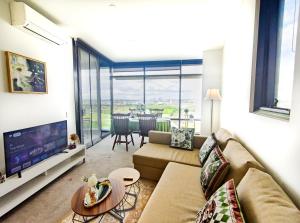 a living room with a couch and a tv at Cozy Apt w Park View by Stadiums in Sydney