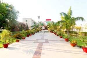a walkway lined with palm trees and plants at OYO Flagship Sangam Resort in Shāhpur