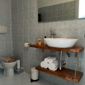 Un baño con un lavabo y una pila de toallas. en Archetto della Verità, en Viterbo