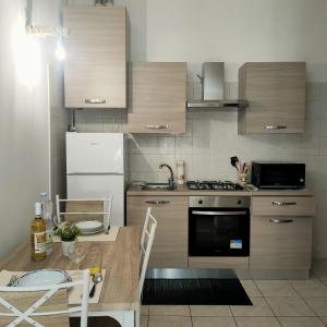 cocina con mesa, fogones y nevera en Archetto della Verità, en Viterbo
