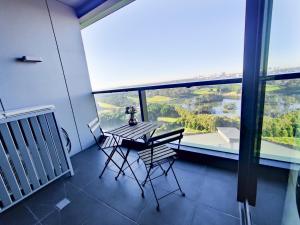 a table and chairs in a room with a large window at Cozy Apt w Park View by Stadiums in Sydney