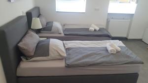 two beds in a bedroom with towels on them at Pension Bad Soden / Apartment and Rooms in Bad Soden am Taunus