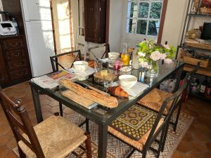 una mesa de comedor con comida y pan. en Maison Garesché, en Nieulle-sur-Seudre