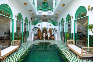 a pool in the lobby of a hotel with two people standing near it at Pisces Hotel Hue in Hue