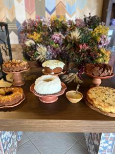 a table with pies and other desserts on it at Eco Resort Pedra Bonita in Santo Estêvão