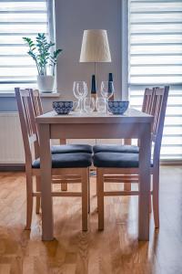 una mesa de madera con sillas y copas de vino. en Cosy and Comfortable Apartment in Cracov, en Cracovia