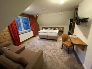 um quarto com uma cama, um sofá e uma mesa em Berggasthof Tönsblick em Oerlinghausen