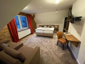 a bedroom with a bed and a couch and a table at Berggasthof Tönsblick in Oerlinghausen