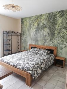 a bedroom with a bed with a tropical wallpaper at L'Hacienda in Les Mathes