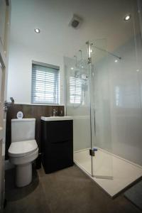 a bathroom with a toilet and a glass shower at Binevenagh View, Magilligan Holiday Let in Limavady