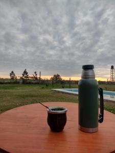 uma garrafa térmica e uma chávena numa mesa com uma bebida em Casa de campo Los Cardenales em Rafaela