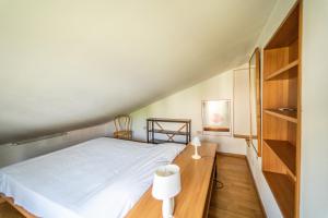 - une petite chambre avec un lit et un bureau dans l'établissement Visogliano Roomy Apt w/ Terrace near the Station, à Sistiana
