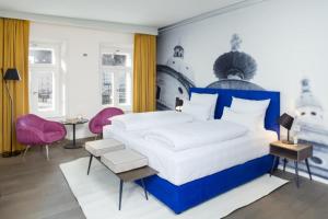 1 dormitorio con 1 cama grande y sillas rosas en Hotel Stein - Adults Only en Salzburgo