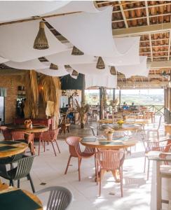 an empty restaurant with tables and chairs and tables and chairs at Eco Resort Pedra Bonita in Santo Estêvão