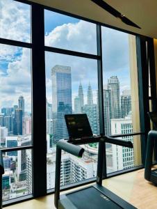 an office with a laptop on a treadmill in front of a window at AXON Suites Bukit Bintang By Sky Pool in Kuala Lumpur