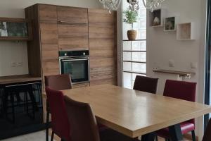 uma cozinha com uma mesa de madeira e cadeiras em BIENVENUE88 em Chessy