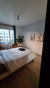 1 dormitorio con cama y ventana grande en BIENVENUE88, en Chessy