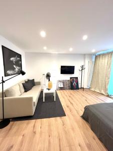 ein Wohnzimmer mit einem weißen Sofa und einem TV in der Unterkunft X-Hain Kiezwohnung in Berlin