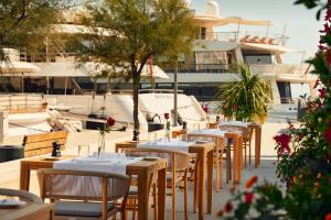 a row of tables and chairs in a marina with boats at Hotel Ambasador in Split