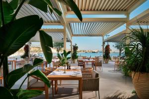 a restaurant with tables and chairs with a view of the water at Hotel Ambasador in Split