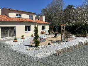 a house with a garden in front of it at Maison sous les chênes in Le Gua