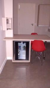 a kitchen with a table and two red chairs at Flow Motel (Adult Only) in Valinhos