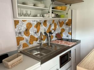 a kitchen with a sink and a counter top at Maison sous les chênes in Le Gua