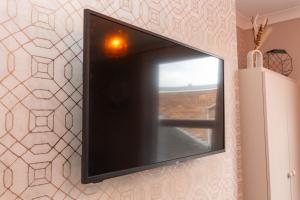 a flat screen tv hanging on a wall at Spalding Town Centre Luxury Private Apartment in Spalding