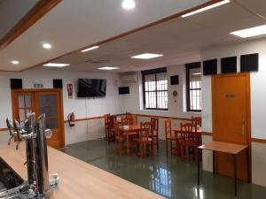 a dining room with wooden tables and chairs at Hostal Extrelucía in Calzadilla