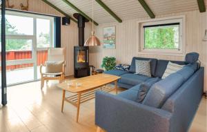 sala de estar con sofá azul y mesa en Stunning Home In Blvand With Sauna, en Blåvand