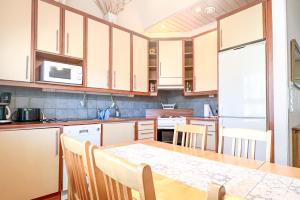 a kitchen with a wooden table and a kitchen counters at Lomahuoneisto Kalajoen Hiekat B 4 in Kalajoki