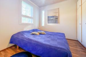 a bedroom with a bed with a blue comforter at Lomahuoneisto Kalajoen Hiekat B 4 in Kalajoki
