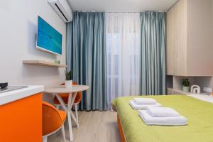 a room with a bed and a table and a kitchen at MYFREEDOM Апартаменти метро Шулявська in Kyiv