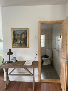 a bathroom with a wooden table and a toilet at Ferielejlighed på Elmensbjerg in Asperup