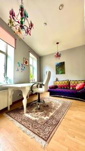 a living room with a white table and a couch at Artistic, colorful apartment with free parking in Riga