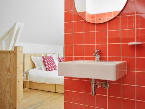La salle de bains est pourvue d'un lavabo sur un mur en carrelage rouge. dans l'établissement Cité des Électriciens, à Bruay-la-Buissière