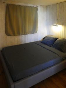 ein großes Bett in einem Zimmer mit Fenster in der Unterkunft UN CHALET EN BOIS A LA PLAGE in Gruissan