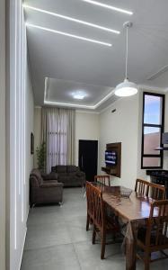 ein Wohnzimmer mit einem Tisch, Stühlen und einem Sofa in der Unterkunft Casa em Brotas in Brotas